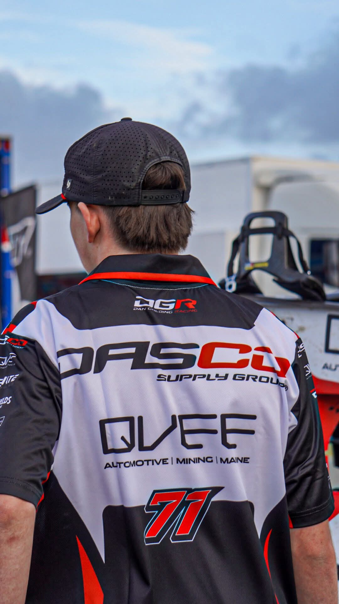crew guy  wearing a branded racing team shirt.